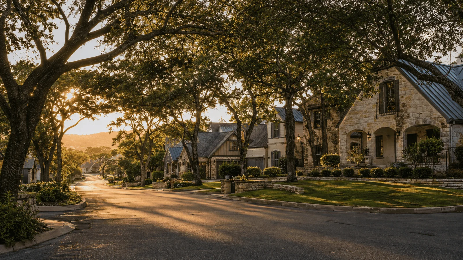 Quiet residential street in New Braunfels, Texas at golden hour with limestone homes and mature oak trees.