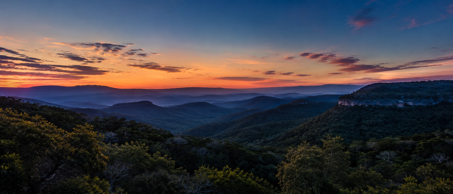 Twilight silhouette of Texas Hill Country hills outside New Braunfels with a warm residual horizon glow.